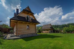 a log cabin with a balcony and a gazebo at Domek Regionalny Dan Pio in Zakopane