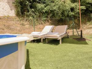 een paar ligstoelen op het gras bij Beautiful holiday home with private pool in Anthé