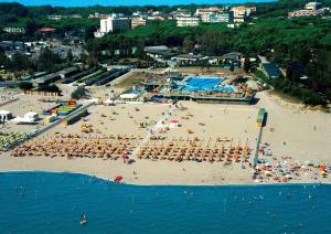 una spiaggia con un gruppo di persone sedute sulla sabbia di Hotel Sole a Rosolina Mare