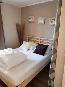 ein Schlafzimmer mit einem Bett mit weißen Laken und Kissen in der Unterkunft Marina village in Saint Cyprien Plage