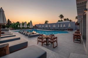 a pool with chairs and tables and umbrellas at Diamond Boutique Hotel in Kos