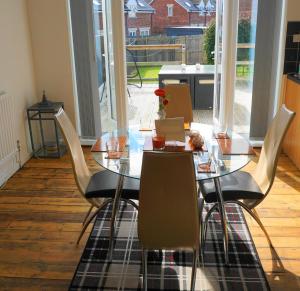 a dining room table with chairs and a glass table at Farneholm in Beadnell