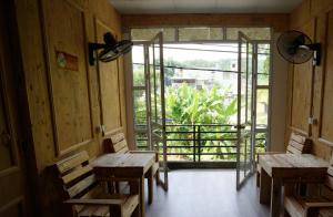 2 bancs dans une pièce avec une porte ouverte dans l'établissement Ha Giang Creekside Homestay and Tours, à Ha Giang