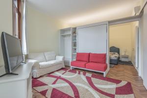 a living room with a couch and a red chair at Ca de le Colonnette - St Marks Square in Venice