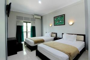 سرير أو أسرّة في غرفة في Hotel Bugis Asri