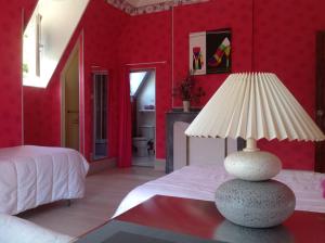 - une chambre avec des murs rouges et une lampe sur une table dans l'établissement Chambres d'hôtes " Les Cascatelles", à Ax-les-Thermes