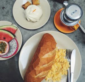 une table avec des assiettes de nourriture et un pain et des fruits dans l'établissement Ha Giang Creekside Homestay and Tours, à Ha Giang