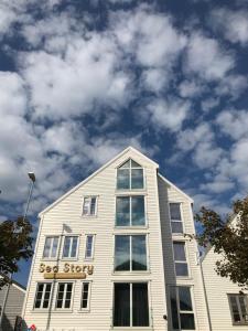 a white building with a sign on the top of it at Sea Story by Frogner House in Stavanger