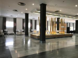 a lobby with columns and tables in a building at Hotel TRH La Motilla in Dos Hermanas