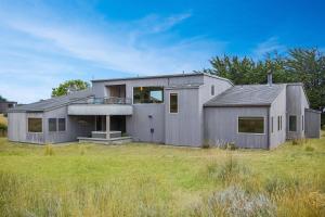 a gray house in a field of grass at Meadow House in Sea Ranch