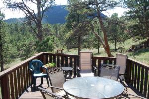 a patio with tables and chairs on a wooden deck at Hummingbird Hideout in Estes Park