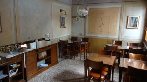 une salle à manger avec des tables et des chaises en bois dans l'établissement Albergo Giulia Gonzaga, à Sabbioneta