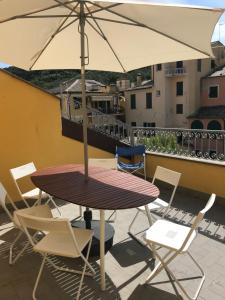 a table and chairs with an umbrella on a balcony at Appartamento Dante Alighieri in Levanto