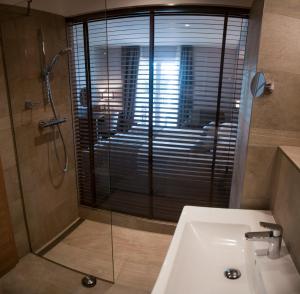 a bathroom with a shower and a sink and a glass shower at Hotel Marina in Izola