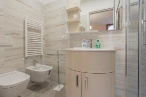 a white bathroom with a sink and a toilet at Ca de le Colonnette - St Marks Square in Venice