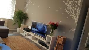 ein Wohnzimmer mit einem TV in einem weißen Unterhaltungszentrum in der Unterkunft New Contemporary Flat minutes from Airport & NEC in Marston Green