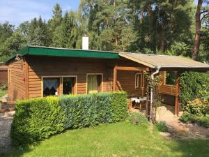 a log cabin with a green roof and a yard at Holzhaus Trollblümchen am Wald und See in Neuruppin