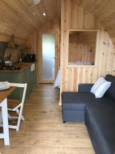 a living room with a couch and a table at Cil y Coed Luxury Pod in Machynlleth