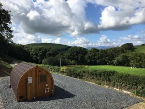 a wooden hobbit house on the side of a road at Cil y Coed Luxury Pod in Machynlleth +4 photos