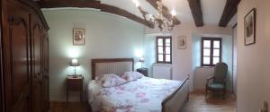 a bedroom with a bed with a floral bedspread at Le Cottage Lavastrie in Lavastrie