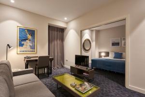 Habitación de hotel con sofá, cama y mesa en M Suite Hotel en Argel