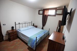 1 dormitorio con 1 cama y TV de pantalla plana en Casa Santina, en Girasole