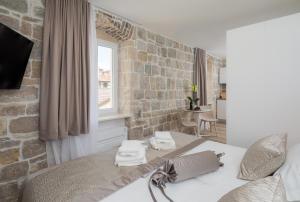 a bedroom with a bed and a brick wall at Mediterra Residence in Split