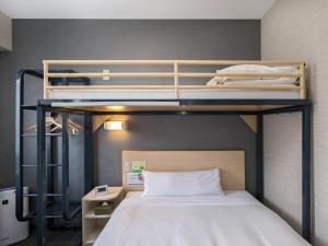 two bunk beds in a small room with a bed at Super Hotel Matsumoto Ekimae in Matsumoto