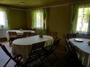 a dining room with tables and chairs and windows at Flower Bell in Ghimeş-Făget