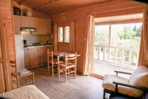 a kitchen with a table and a large window at Chalets 1 MESANGE BLEUE Roquebrune Sur Argens in Roquebrune-sur-Argens +23 photos