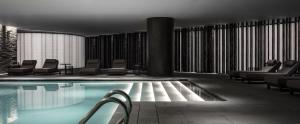 una piscina en un hotel con sillas y mesas en The Middle House en Shanghái