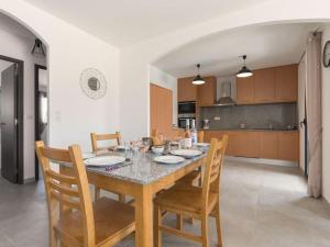 a dining room table with chairs and a kitchen at Le Domaine De Marie in Palasca