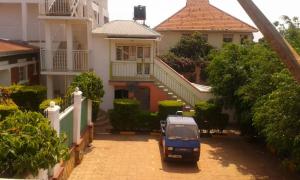 a blue truck parked in front of a house at Tourist Nest Hotel in Kampala