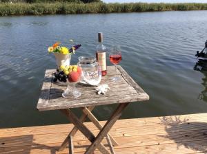 a table with wine glasses and wine bottles on a dock at Feriendomizil Wohltat in Wilhelmshof