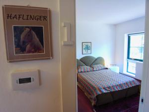 a bedroom with a bed and a picture of a horse on the wall at Società Agricola La Staccionata in Staranzano