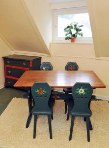 a dining room table with four chairs and a window at Landhaus Zur Eiche in Sittensen