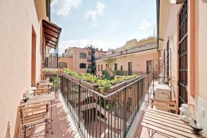 uma varanda de um edifício com bancos e plantas em Peroni 8 Pax Brand New Apartment em Roma