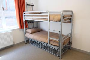 a couple of bunk beds in a room with a window at Black Isle Hostel in Inverness
