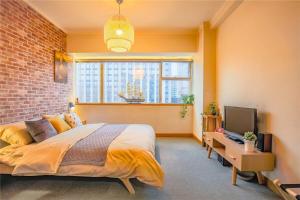 a bedroom with a bed and a tv and a brick wall at Hangzhou Xihu District ·Huanglong Sports Center Locals Apartment 00147450 in Hangzhou