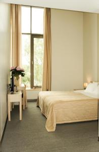 a bedroom with a large bed and a window at Zaliasis slenis - Self check-in hotel in Klaipėda