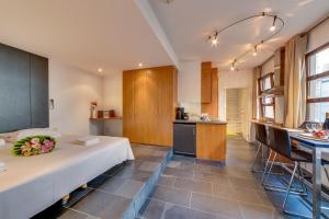 a room with a large white bed in a kitchen at Grand Place Charbon Residence in Brussels