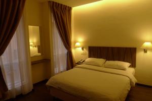 1 dormitorio con 1 cama blanca y 2 ventanas en 9 Square Hotel - Petaling Jaya, en Kota Damansara