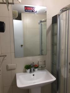 bagno con lavandino bianco e specchio di Condotel a Baguio