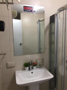 a bathroom with a white sink and a mirror at Condotel in Baguio