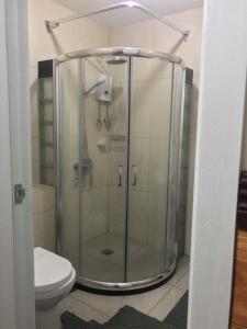 a glass shower in a bathroom with a toilet at Condotel in Baguio