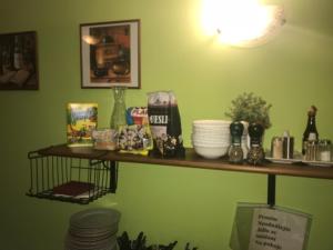 a shelf on a green wall with dishes on it at Penzion Seidl in Rokytnice nad Jizerou