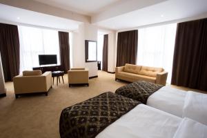 a hotel room with a bed and a living room at Harmony Hotel Baku in Baku