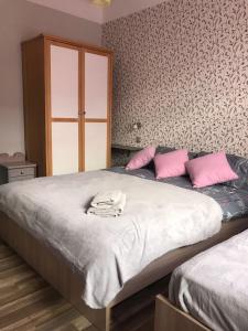 een slaapkamer met 2 bedden en roze kussens bij Apartment "Flowers" in Rīga