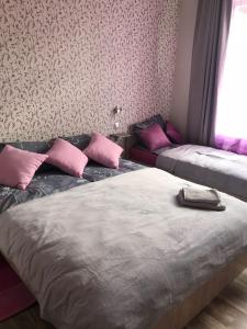 two beds in a room with pink pillows at Apartment "Flowers" in Rīga