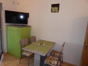 ein kleines Esszimmer mit einem grünen Tisch und Stühlen in der Unterkunft Apartmani Nin in Nin